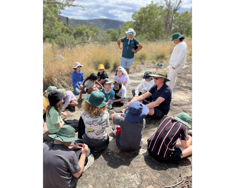 Students sitting in the bush while on Crew Camp.