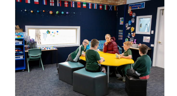A photo of our Multi-catergorical class. A teacher with four students sitting at a table together.